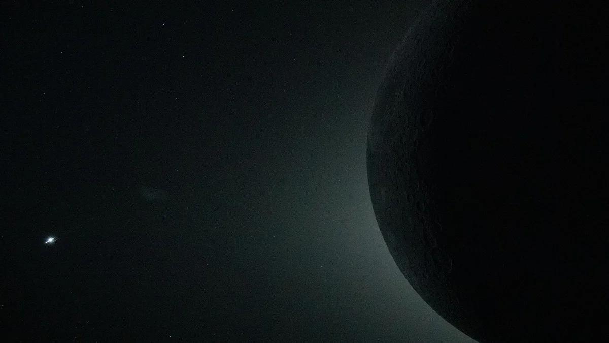Partial view of the total solar eclipse from Artemis II showing the Moon's edge blocking the Sun, with Venus visible as a bright point of light nearby