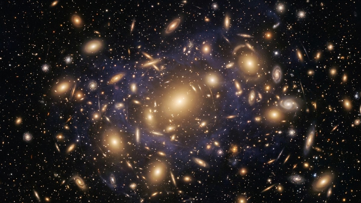 A rich galaxy cluster with dozens of glowing elliptical galaxies surrounded by hot intergalactic gas