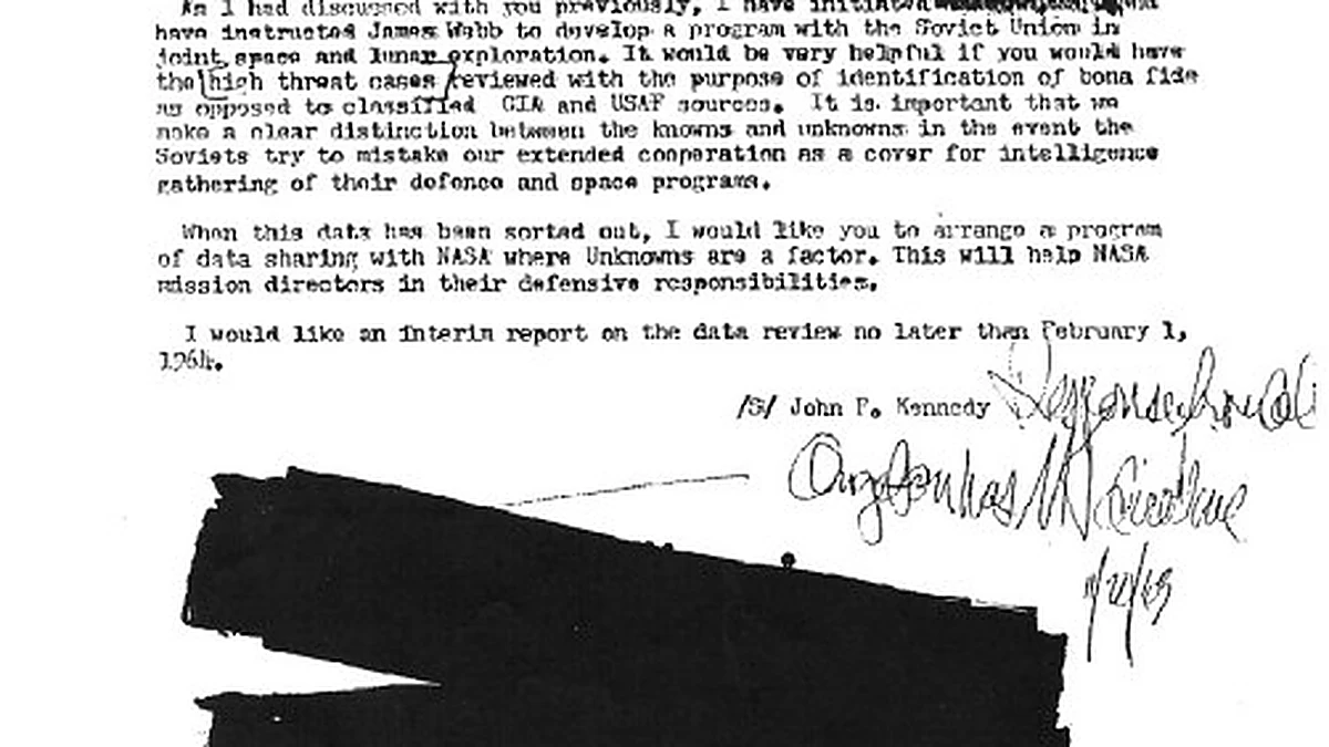 The lower half of the alleged JFK UFO memo, showing the typed signature block reading /s/ John F. Kennedy, handwritten annotations and a large black redaction