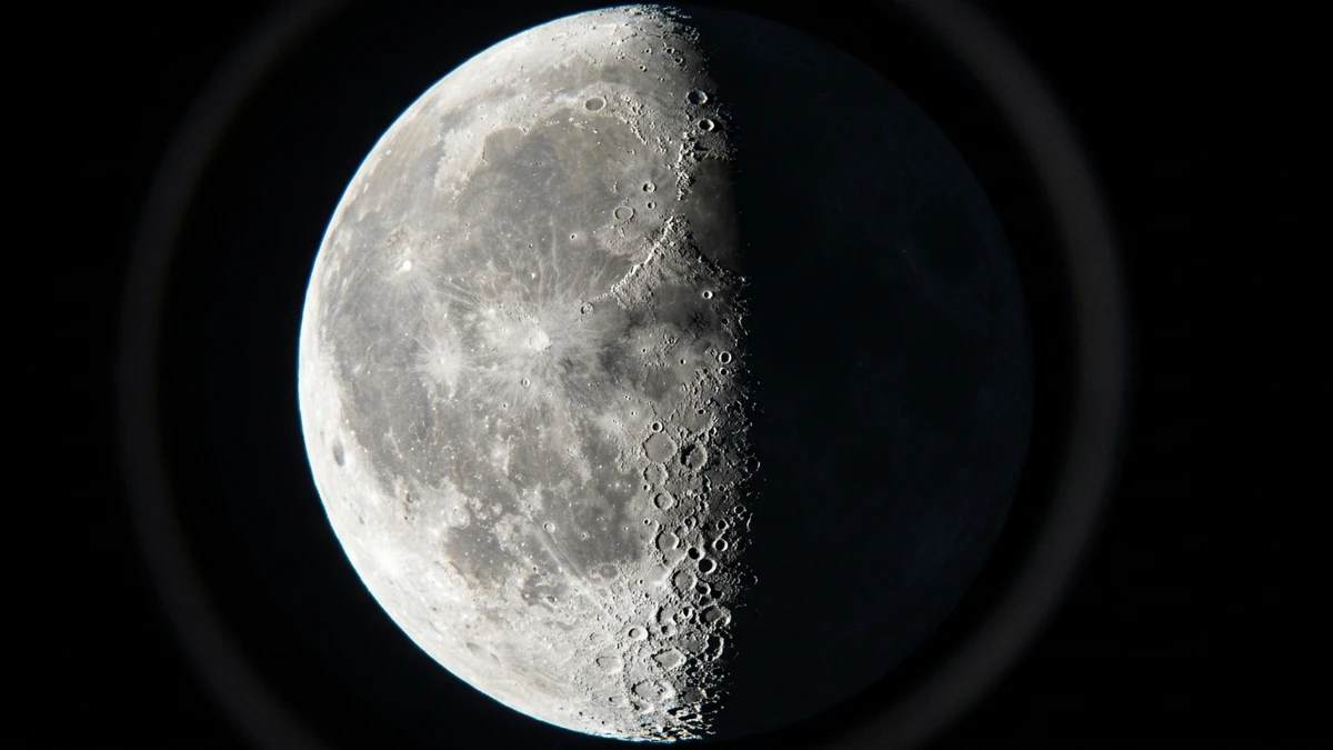 The first quarter Moon through a telescope, with craters thrown into sharp relief by long shadows along the terminator