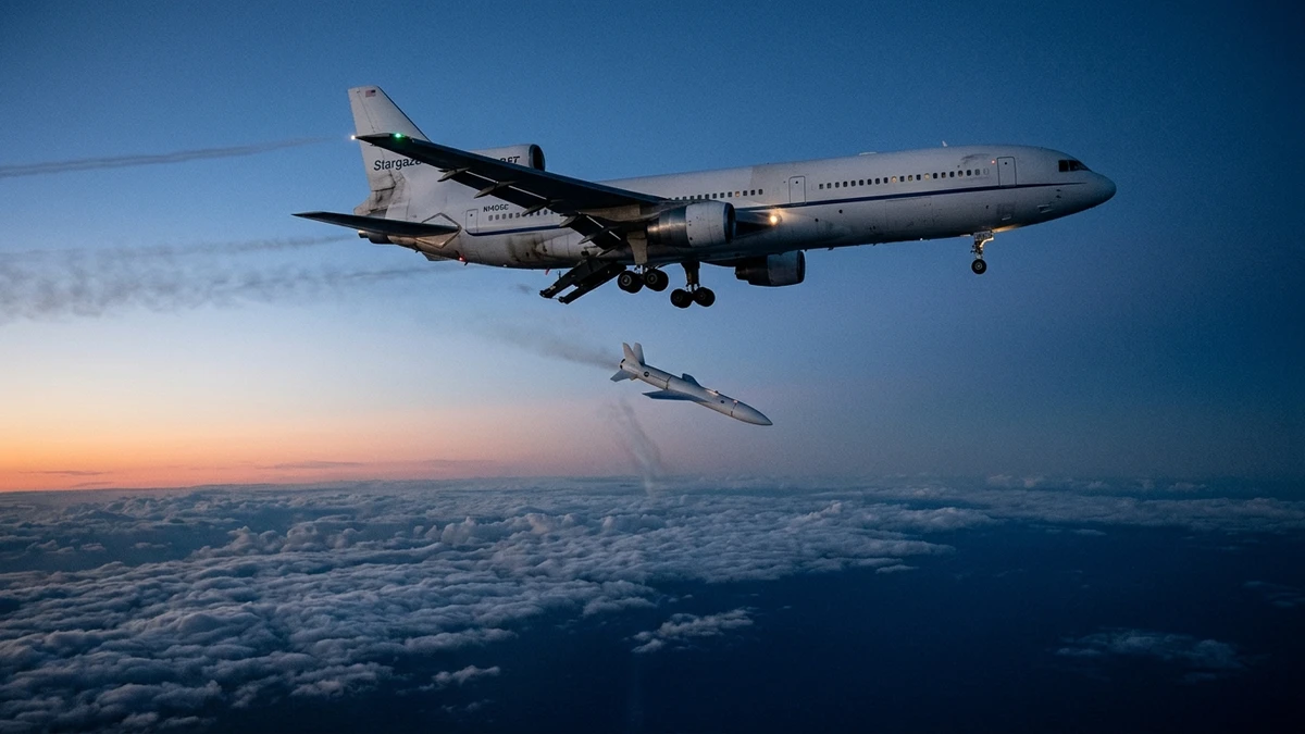 A Pegasus XL rocket falling away from the Stargazer L-1011 aircraft over the Pacific, its motor igniting against the evening sky