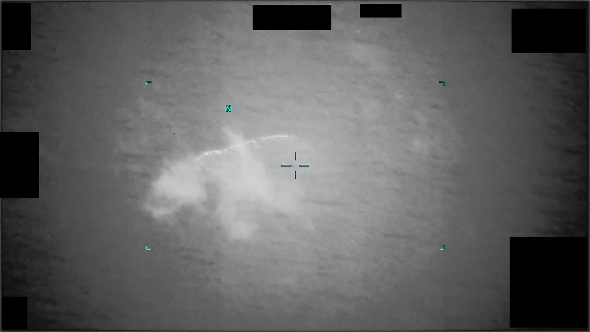 Blurry monochrome infrared frame from DOW-UAP-PR101 showing an elongated bright smear at the centre of the frame against a grainy background, with a tracking reticle and small corner markers