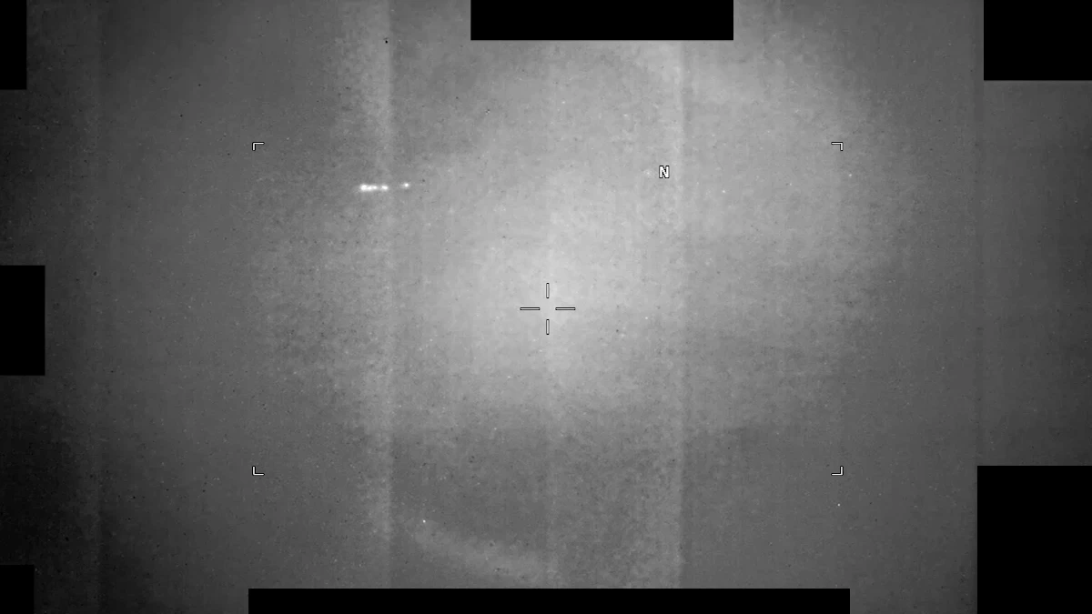 Frame from the infrared video PR135 at 20 seconds: a grey sensor view with a crosshair in the middle and a short row of small white specks up and to the left, with black redaction blocks around the edges