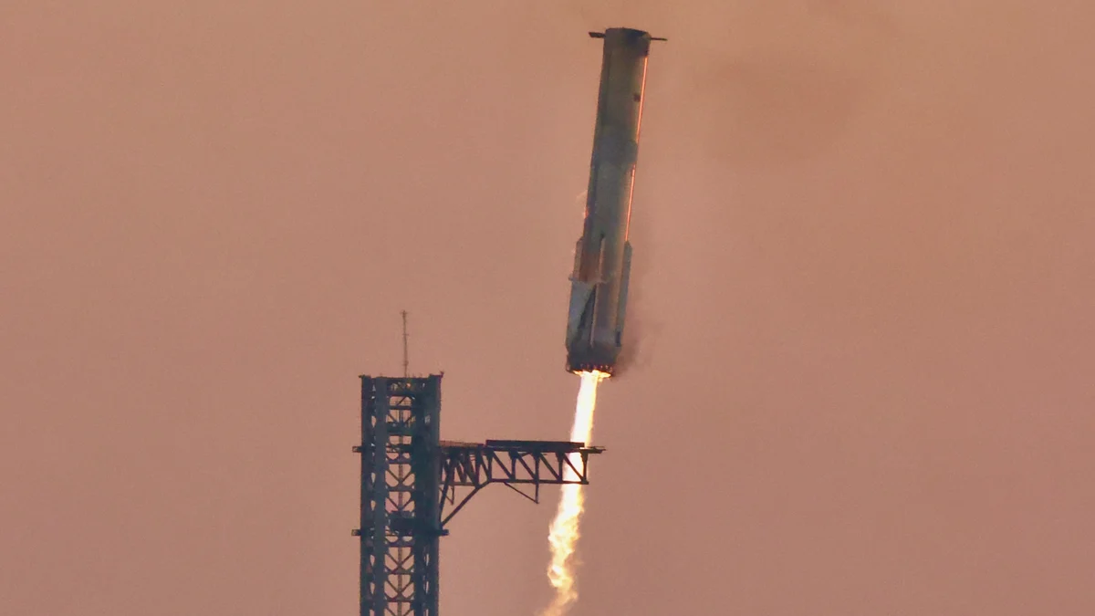 A Super Heavy booster descending on a single flame towards the arms of its launch tower at sunset