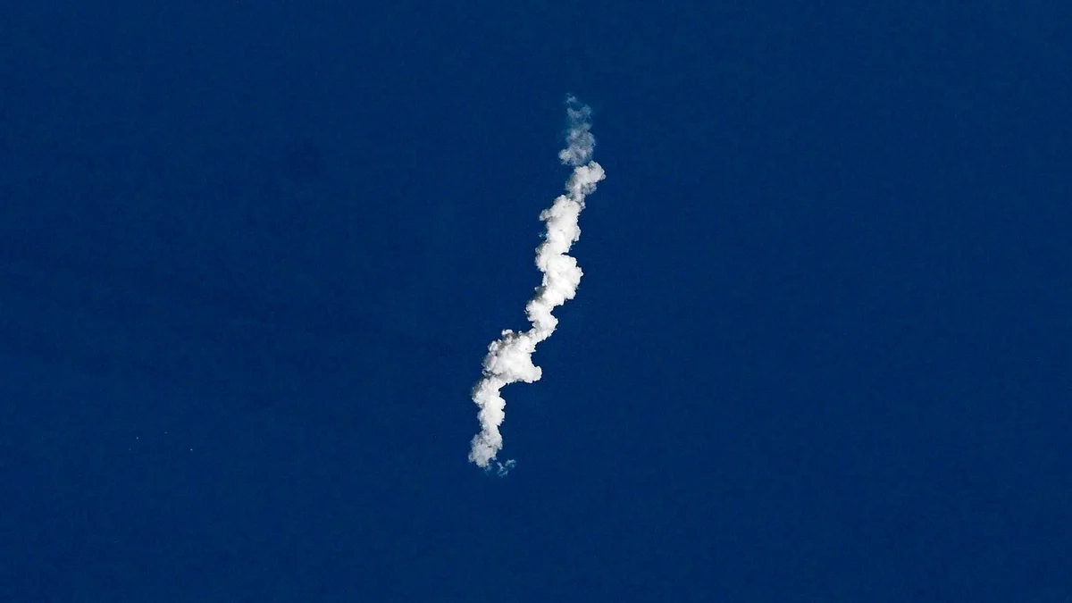 A white, twisting exhaust trail from a Starship launch seen from above against the dark blue Gulf of Mexico