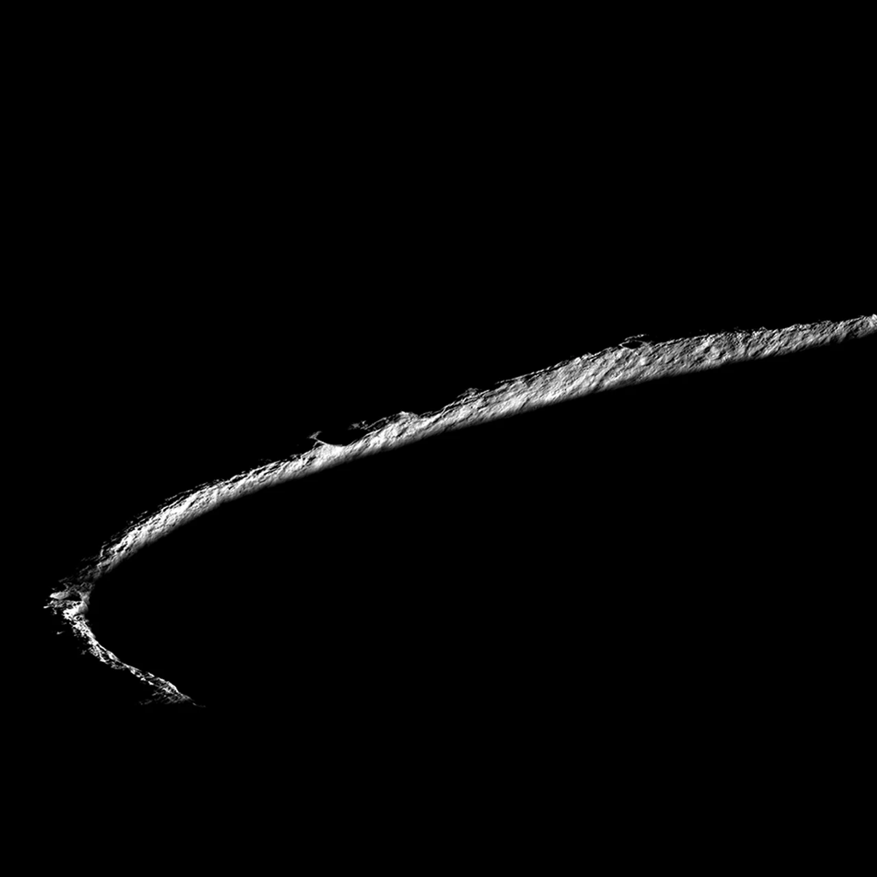 Shackleton Crater at the lunar south pole imaged by NASA's Lunar Reconnaissance Orbiter — a dramatic image showing the sunlit crater rim forming a bright arc against the permanently shadowed, completely dark crater interior