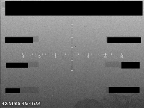 Redacted sensor image with a targeting reticle.