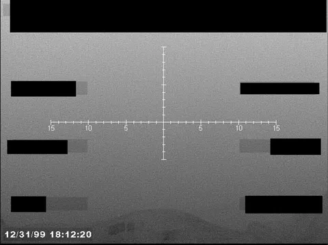 Redacted sensor image with a targeting reticle.