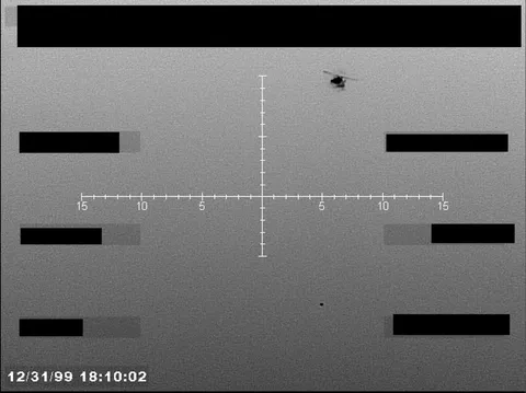 Redacted sensor image with a targeting reticle and a visible object.