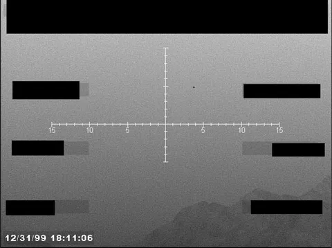 Redacted sensor image with a targeting reticle.