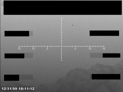 Redacted sensor image with a targeting reticle.