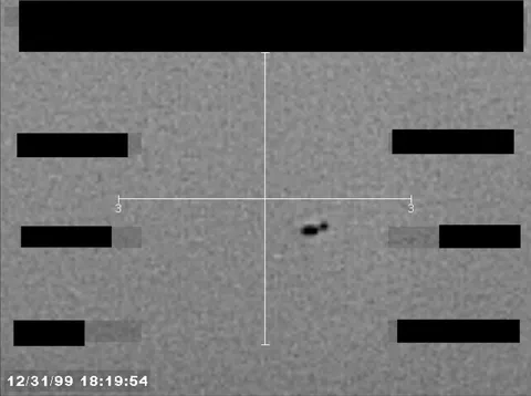 Redacted sensor image with a crosshair targeting a visible object.
