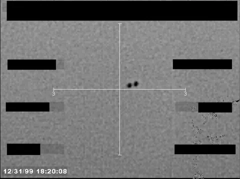 Redacted sensor image with a crosshair targeting a visible object.