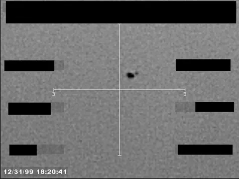 Redacted sensor image with a crosshair targeting a visible object.