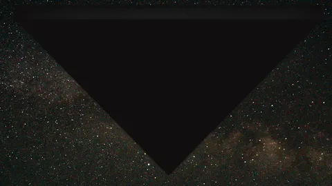 A digital rendering of a large, dark triangle against a starry night sky.