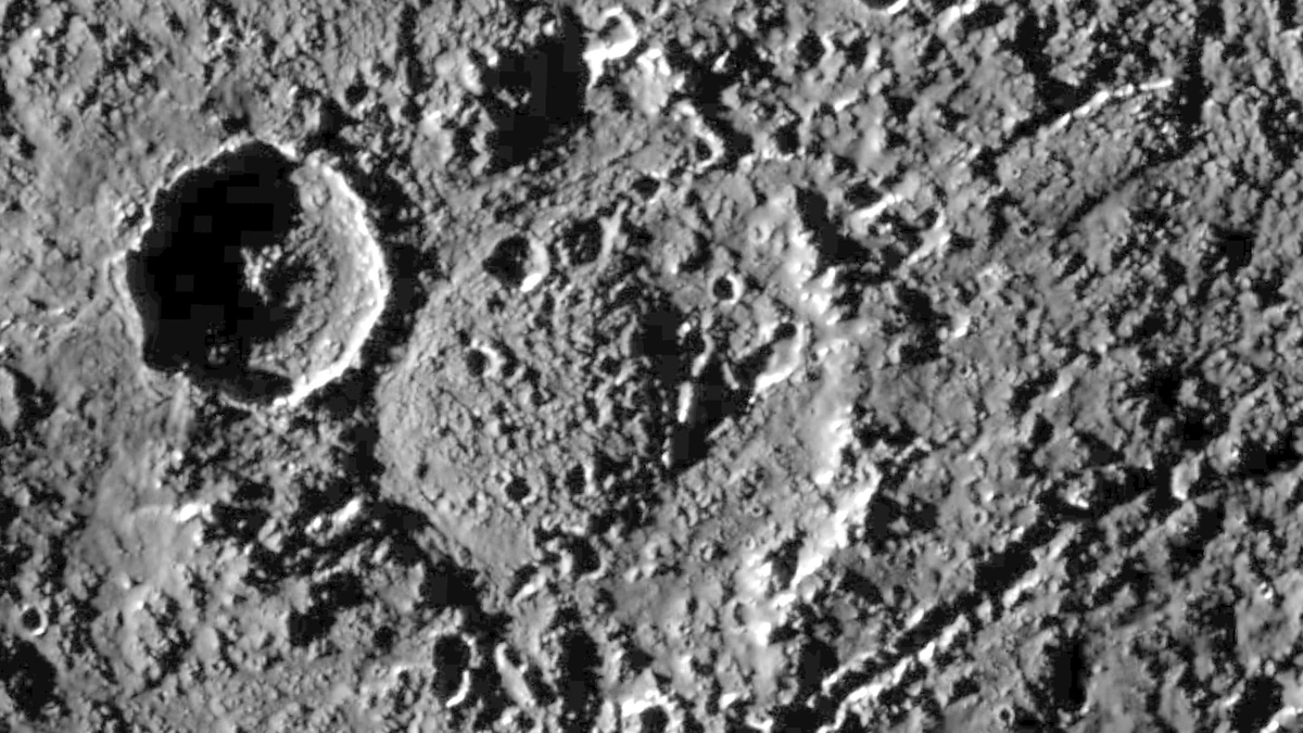 A heavily cratered region of Callisto in black and white, with the large double-ring crater Har and a younger crater on its western rim, photographed by Galileo