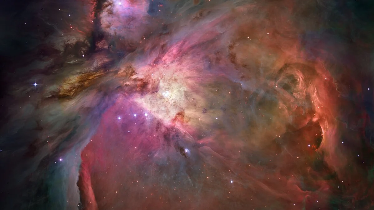 Hubble Space Telescope image of the Orion Nebula, a swirling cloud of glowing pink, orange and blue gas lit by young stars at its centre