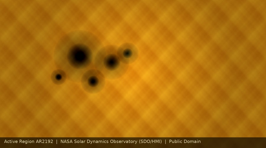 Close-up of active sunspot group AR2192 on the solar photosphere, showing dark umbrae and surrounding penumbrae against the granulated solar surface